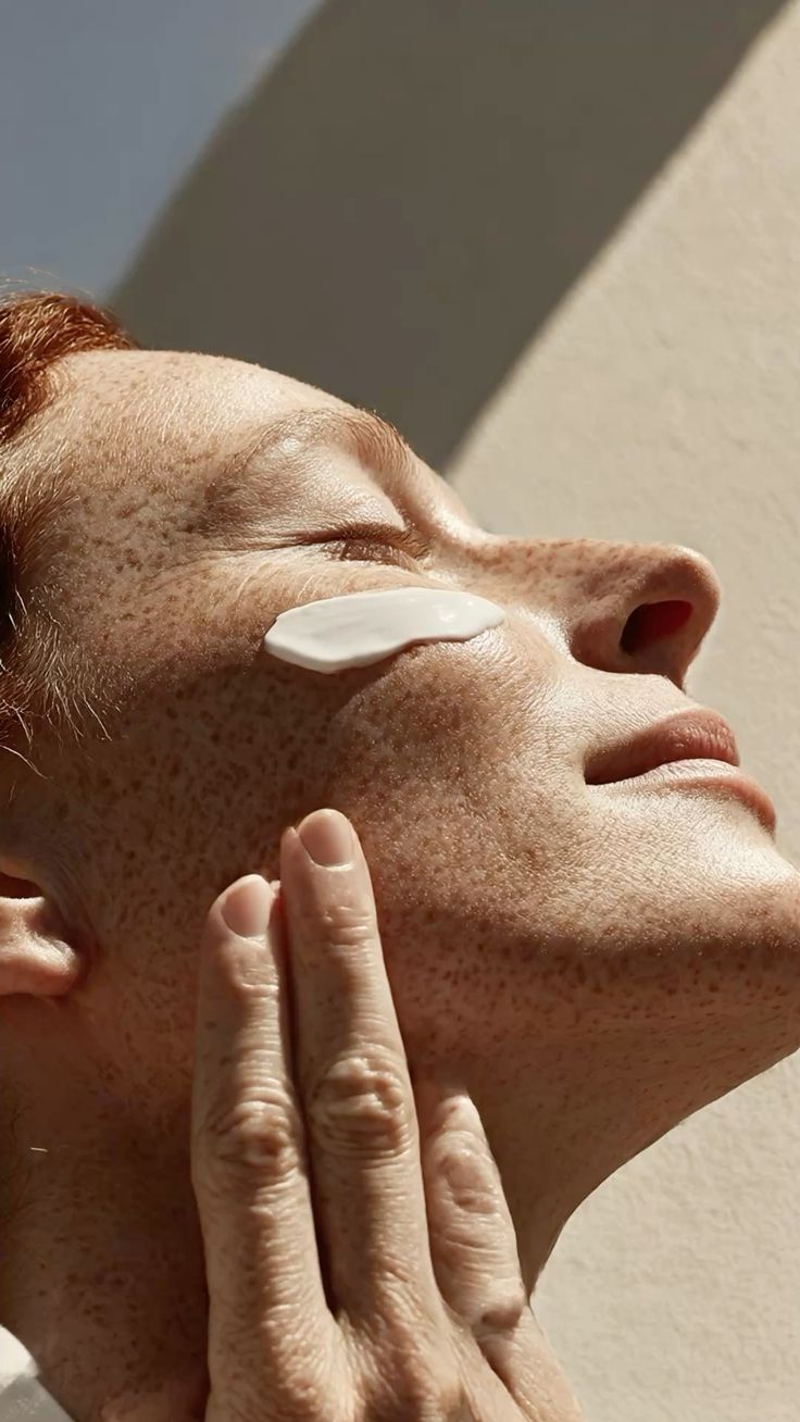 Mujer aplicándose InfiniteGlow al sol
